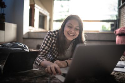 happy teen girl at laptop